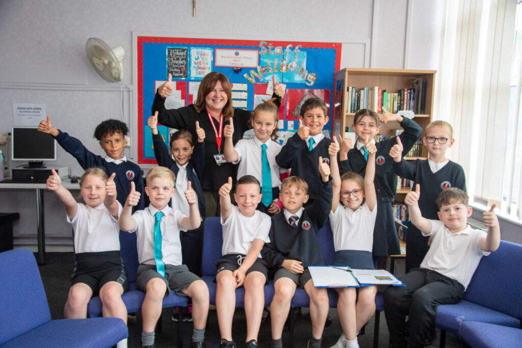 a picture of a class with their thumbs up