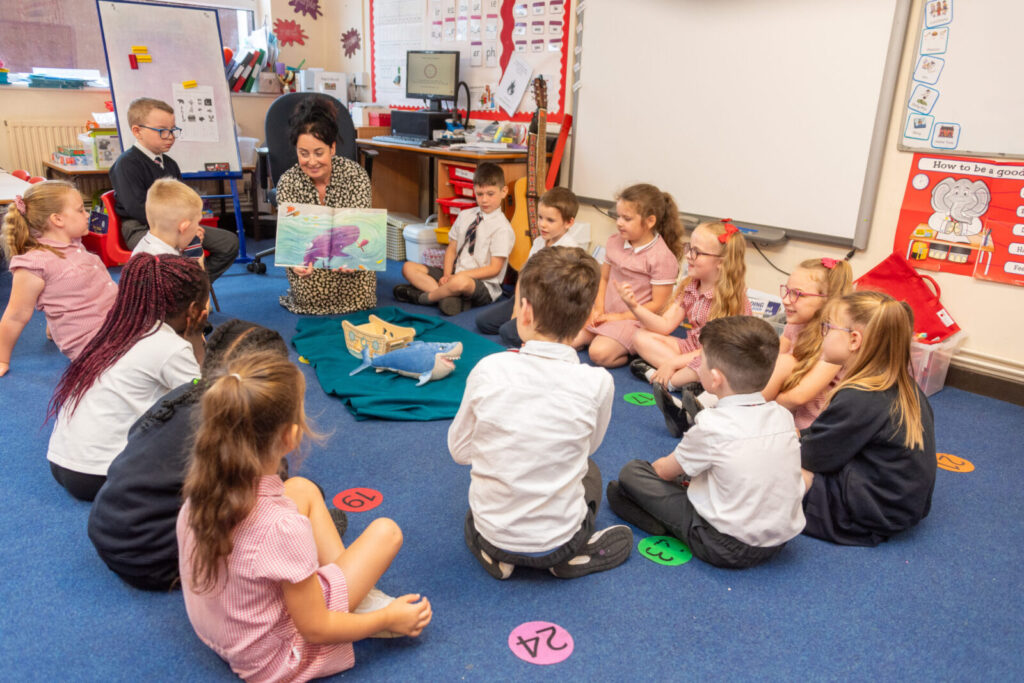 a picture of a teacher showing the class a book